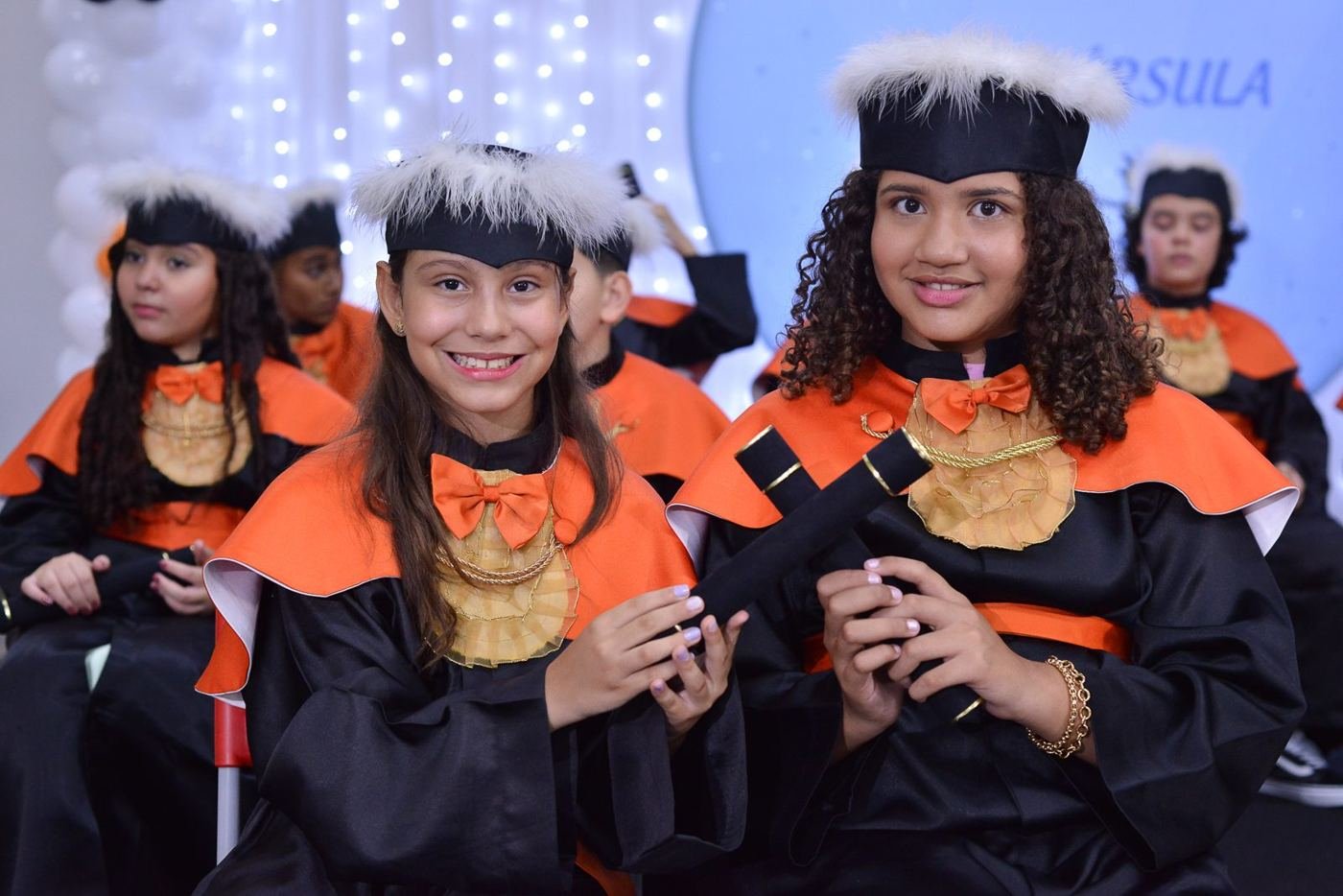 Formandas sorrindo durante a cerimônia